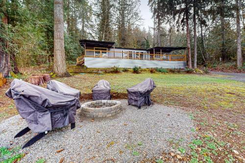 a house with a fire pit in front of it at WatersView Tree House in Shelton