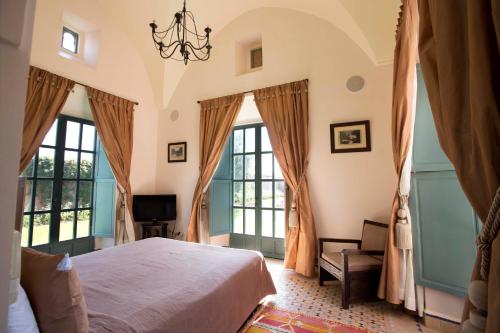 a bedroom with a large bed and windows at Villa Jannah in Marrakech