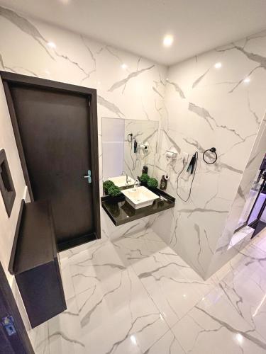 a white bathroom with a sink and a mirror at Shopping Motel in Castanhal