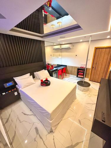 a bedroom with a large white bed and a table at Shopping Motel in Castanhal