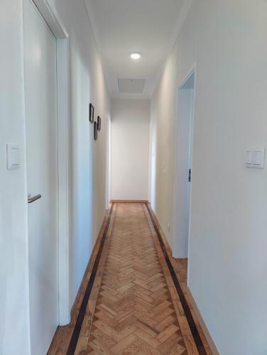 an empty hallway with white walls and a wooden floor at A Casa das Tias in Benedita