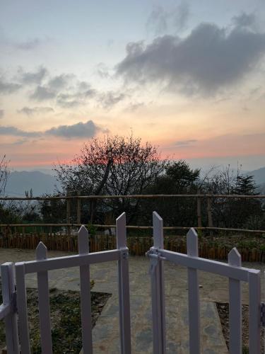 a white fence with a sunset in the background at JijiVisha in Kīar
