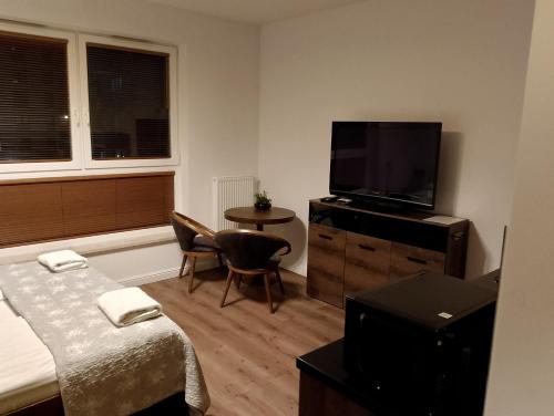 sypialnia z łóżkiem i telewizorem z płaskim ekranem w obiekcie Apartament Bastion Wałowa Gdańsk w Gdańsku