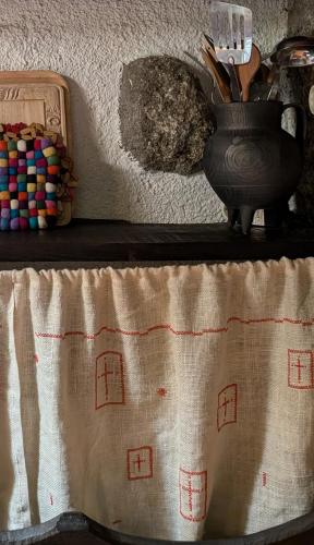a table with a vase on top of a table at Casa das 5 Cruzes dentro da muralha in Sortelha
