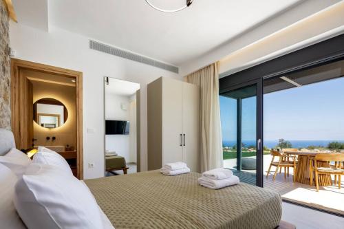 Un dormitorio con una cama y un balcón con vistas. en Agapanthus Ultimate Luxury Villa, en Likotinaréa