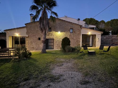 a house with a palm tree in front of it at Mas El Casot 1 in Vilademuls