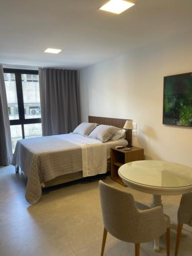une chambre d'hôtel avec un lit, une table et une table dans l'établissement Alive View, à Salvador