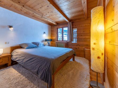 une chambre avec un lit dans une cabane en bois dans l'établissement 2 spacieux appartements dans une ferme rénovée face au MontBlanc, à Megève