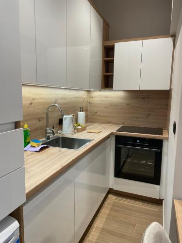 a kitchen with white cabinets and a sink at Moaline Apartments, free parking in Sarajevo