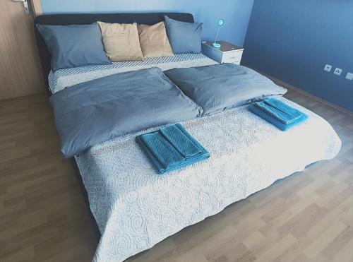 Una cama con dos almohadas azules encima. en Pretty Nice view Apartment, Private Parking, 8min to center by car, en Bratislava
