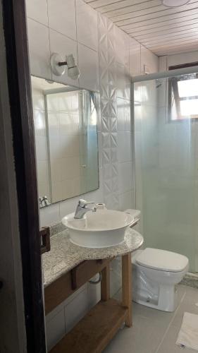 a bathroom with a sink and a toilet and a mirror at Casa na Praia in Torres
