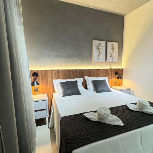 a bedroom with a bed with two hats on it at Pousada Brumado in Brumado