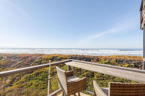 a balcony with two chairs and a view of the ocean at 7 Pelican! Sweeping Ocean Views & Front Row Beach Access in Watsonville