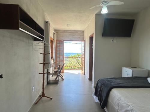 a bedroom with a bed and a window with a view at Pousada do Cid in São Thomé das Letras