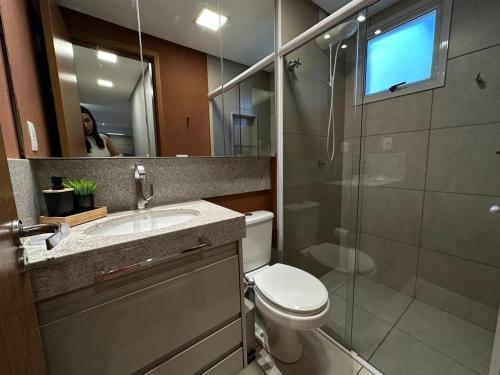 a bathroom with a toilet and a sink and a mirror at iFlat Winner Sport Life Jardim Goiás in Goiânia