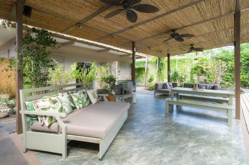 an outdoor patio with a couch and a table at Tamarindo Bay Boutique Hotel, Apartments & Suites in Tamarindo