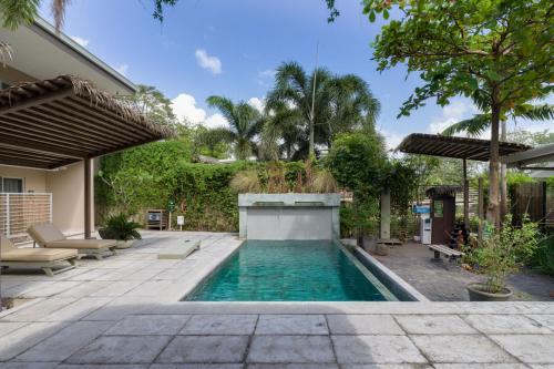 a swimming pool in the backyard of a house at Tamarindo Bay Boutique Hotel, Apartments & Suites in Tamarindo