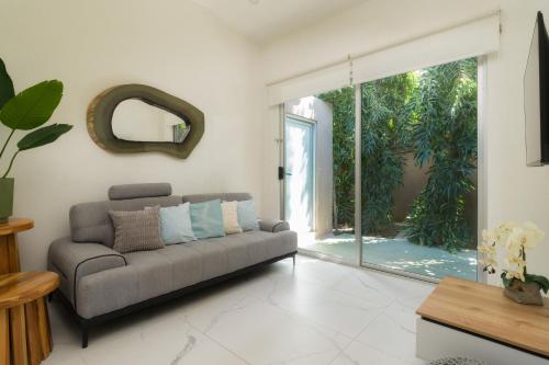 a living room with a couch and a sliding glass door at Tamarindo Bay Boutique Hotel, Apartments & Suites in Tamarindo