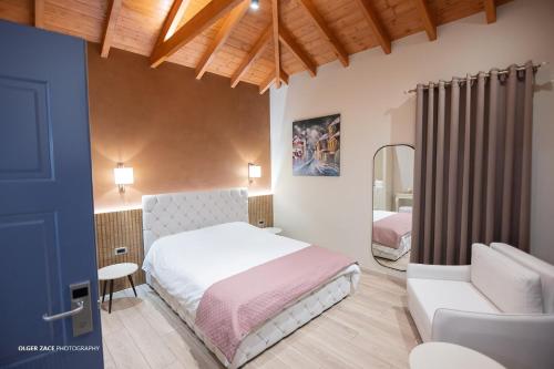 a bedroom with a bed and a chair and a mirror at Moonlight Serenade in Korçë