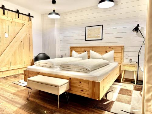 a bedroom with a large wooden bed and a chair at Sweet Home Apartments in Tösens