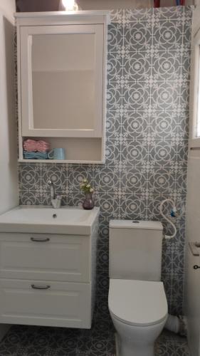 a bathroom with a white toilet and a sink at Stylish Quiet and Central in Rechovot