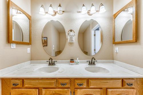 a bathroom with two sinks and two mirrors at Spacious Ruidoso Home with Patio and Mountain Views! in Ruidoso