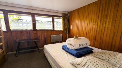 una camera da letto con un letto con un cuscino sopra di Résidence Saint Roch - Appartement T2 lumineux 4 personnes MAE-6811 a Puy-Saint-Vincent