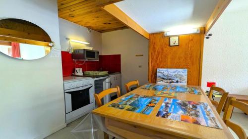 une cuisine avec une table en bois et une salle à manger dans l'établissement Résidence Saint Roch - Appartement T2 lumineux 4 personnes MAE-6811, à Puy-Saint-Vincent