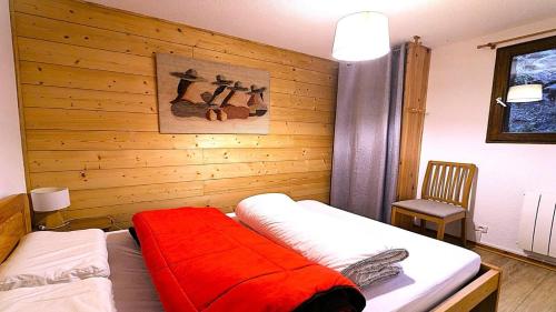 a bedroom with two beds and a wooden wall at Résidence Les Cytises - Agréable T2 avec jardin et terrasse 4/6 personnes MAE-6871 in Vallouise