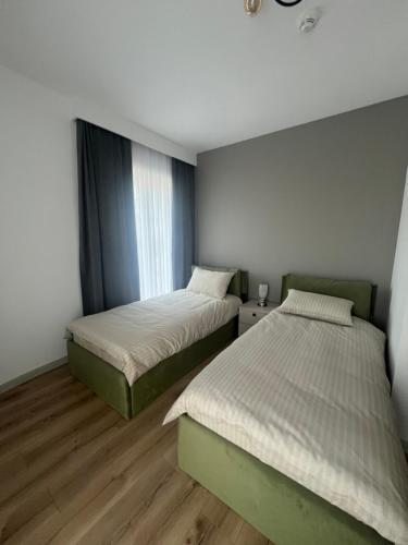 a bedroom with two beds and a window at Amelie's Apartment 2 in Skopje