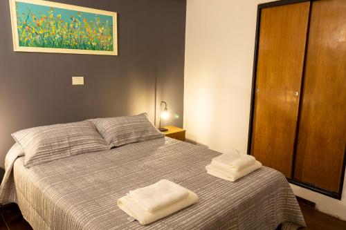 a bedroom with a bed with two towels on it at Hotel W in Neuquén