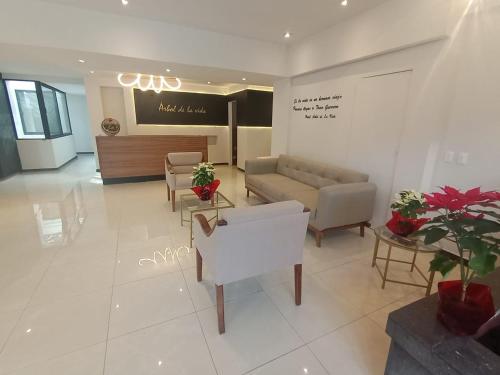 a lobby with a waiting room with a couch and chairs at HOTEL BOUTIQUE ÁRBOL De LA VIDA in Taxco de Alarcón