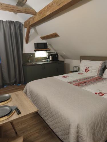 a bedroom with a large bed and a table at Landhof Schober Studio's in Weissbriach