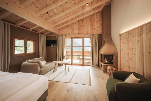 a hotel room with a bed and a fireplace at Naturhotel Lüsnerhof in Luson