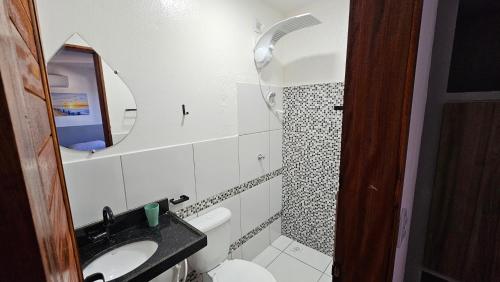 a small bathroom with a sink and a mirror at Chalés Mediterraneo in Flecheiras