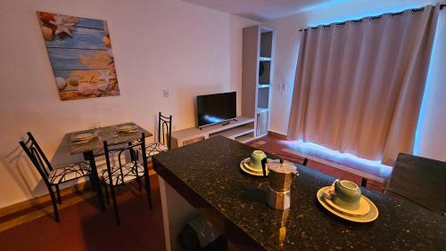a living room with a table and a dining room at Chalés Mediterraneo in Flecheiras