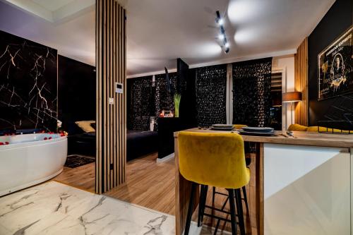 a kitchen with a bar with a yellow stool at Apartament American Express Rzeszów in Rzeszów