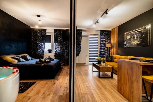 a living room with a bed and a tub at Apartament American Express Rzeszów in Rzeszów