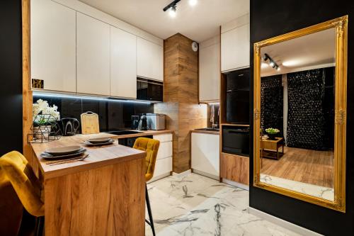 a kitchen with white cabinets and a mirror at Apartament American Express Rzeszów in Rzeszów