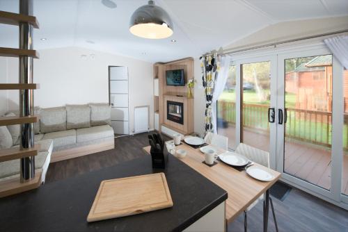 a kitchen and living room with a table and a couch at St. Ives Holiday Village in St Ives