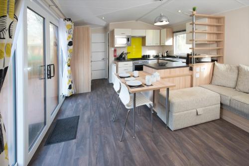 a kitchen and living room with a table and a couch at St. Ives Holiday Village in St Ives