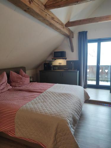 a bedroom with a bed with a red and white comforter at Landhof Schober Studio's in Weissbriach