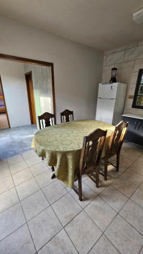 a kitchen with a table with chairs and a refrigerator at Hotel Praia Do Rosa in Praia do Rosa