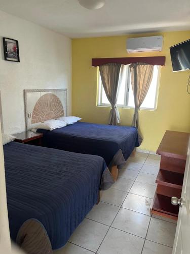 a hotel room with two beds and a window at Hotel Albatros Palace - Bungalow G in Manzanillo