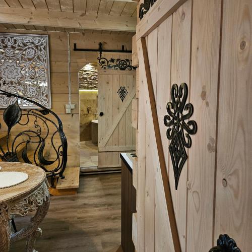 a wooden cabin with a wooden door and a table at Domki góralskie z sauną i jacuzzi in Kościelisko