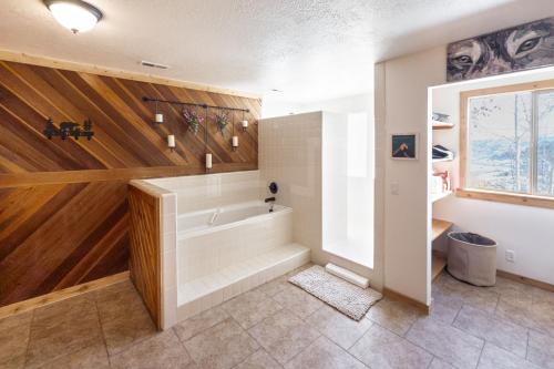 a bathroom with a tub and wooden walls at Cozy Rustic Escape Near Park City Adventures in Park City