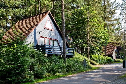 a small house in the woods next to a road at Domaine Long Pre in Stavelot