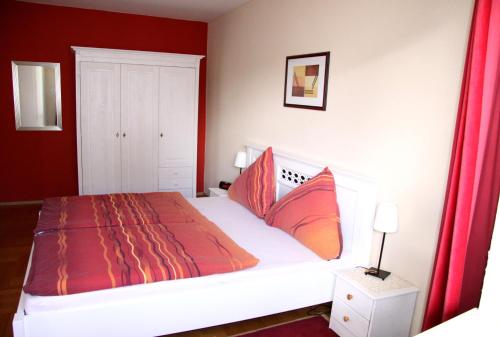 a bedroom with a large bed with red walls at FeWo Bonnita - Nähe UN-Campus u. WCCB in Bonn