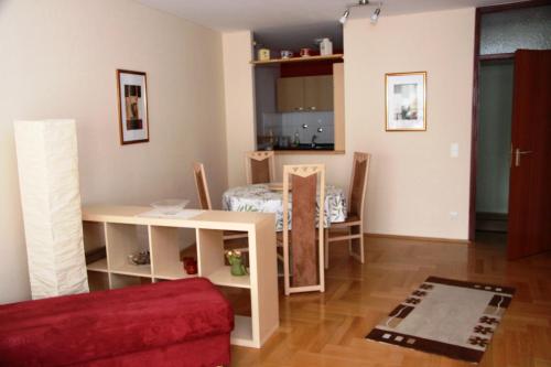 ein Wohnzimmer mit einem Tisch und einem roten Sofa in der Unterkunft FeWo Bonnita - Nähe UN-Campus u. WCCB in Bonn