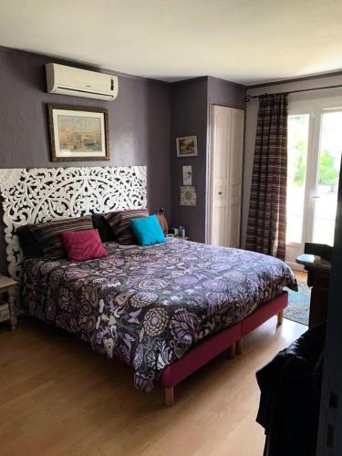 une chambre avec un lit avec des oreillers colorés dessus dans l'établissement Résidence Pins Parasol - Magnifique maison individuelle avec piscine privée et proche de la mer MAE-5211, à Six-Fours-les-Plages